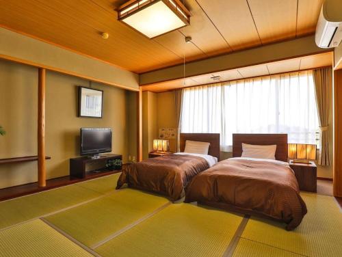 白滨格拉姆普斯西酒店的一间卧室配有两张床和一台平面电视