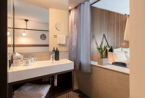 汉堡PIERDREI Hotel HafenCity Hamburg的一间带水槽和大镜子的浴室