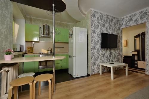 鄂木斯克Omsk Sutki Apartments at Lenina 30的厨房配有绿色橱柜和白色冰箱