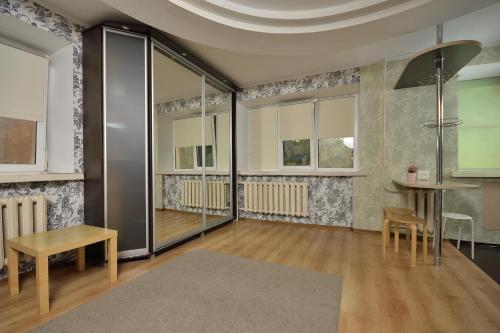鄂木斯克Omsk Sutki Apartments at Lenina 30的客厅配有桌椅、桌子和窗户。