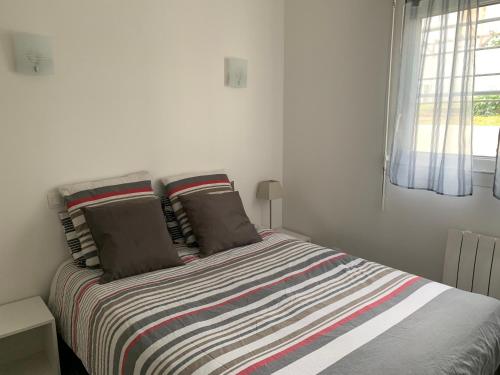 鲁瓦扬Appartement des Tilleuls RDC的一间卧室配有带条纹毯子的床