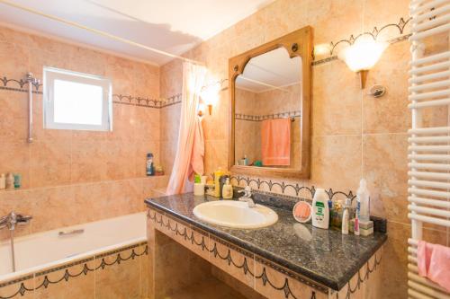 PikérmionPool villa near to airport/free car available的一间带水槽、浴缸和镜子的浴室