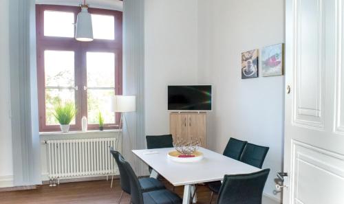 巴特温普芬Wohnung in TOP-Lage - Direkt am Bahnhof的一间配备有白色桌椅的用餐室