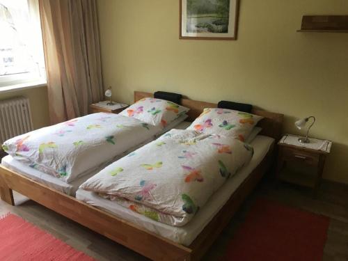 拜尔里舍艾森施泰恩Gästehaus Erna Meier的一间卧室配有两张带白色床单和鲜花的床。