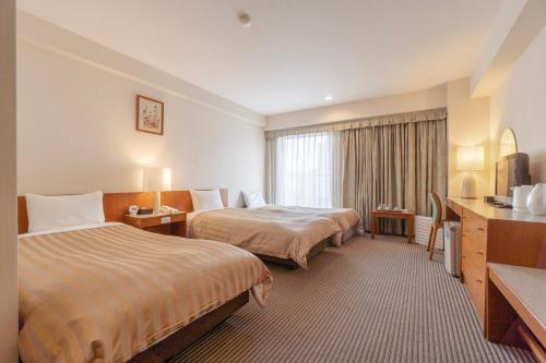 京都金门京都酒店的酒店客房设有两张床和窗户。