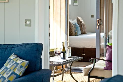 切达Perry Lodge, Strawberryfield Park的一间设有蓝色沙发的房间和一张带葡萄酒的桌子