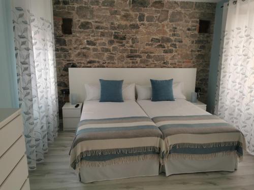 希洪Begoña 18 Rest & Adventure的一间卧室设有一张带砖墙的大床