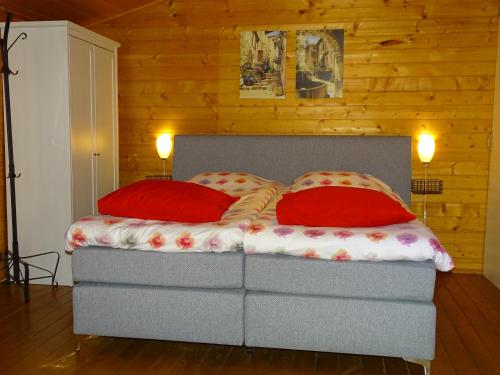 ZeyenB&B Zeijen的一张带两个红色枕头的床