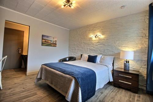 梅干提克湖默特尔勒凯尔特酒店的一间卧室设有一张大床和砖墙