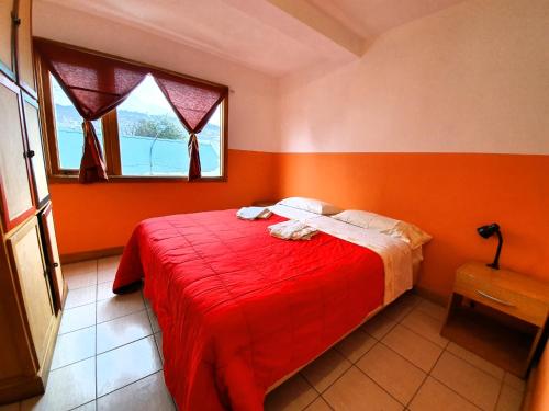 乌斯怀亚YAGHAN HOSTEL的一间卧室设有橙色的墙壁和一张带红色毯子的床。
