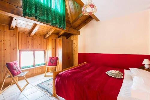 阿贝托内Locanda Farinati的一间卧室配有红色的床和两把椅子