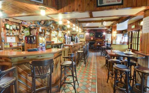 库拉克洛Hotel Curracloe的餐厅内带木墙和凳子的酒吧