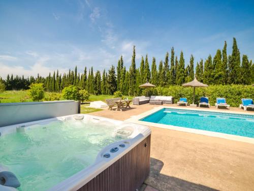 阿尔库迪亚Villa Vertaient by Interhome的庭院内带热水浴池的游泳池
