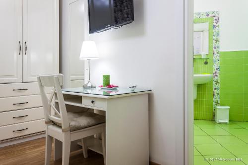 墨西拿大都市住宿加早餐酒店的浴室铺有绿色瓷砖,配有桌椅
