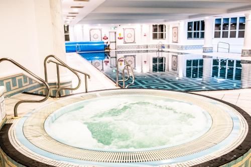 班克拉那伊尼什欧文盖特维酒店的一座带游泳池的建筑中的按摩浴缸