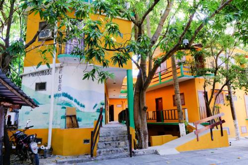 埃斯孔迪多港Hotel Posada Playa Manzanillo的一面有壁画的黄色建筑