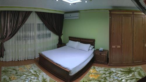 开罗Maadi Apartment - 3 rooms ( Families Only )的卧室配有白色的床和木制橱柜。