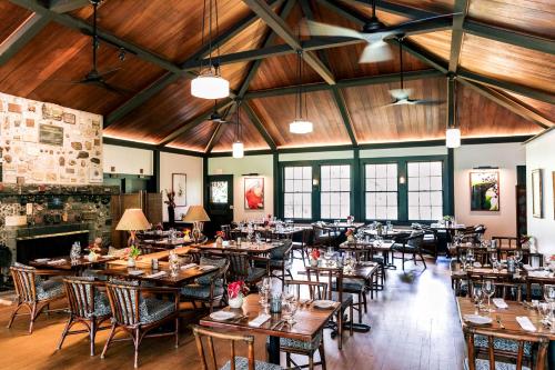 沃尔卡诺Kilauea Lodge and Restaurant的餐厅设有木制天花板和桌椅