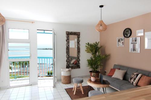 皮特尔角城Ocean View and Exclusive Flat Le croisieriste的带沙发的客厅,享有海景