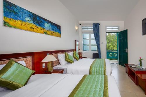峰牙Sai Gon Phong Nha Hotel的酒店客房设有两张床和窗户。