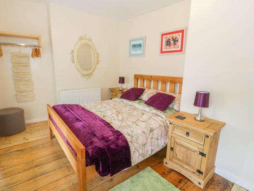 Llanfihangel-y-pennantBwthyn Pennant的一间卧室配有一张床和一张带台灯的桌子