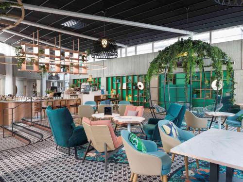 鲁瓦西昂法兰西巴黎戴高乐机场诺富特酒店的一间带桌椅的餐厅和一间酒吧