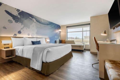 密尔沃基Cambria Hotel Milwaukee Downtown的配有一张床和一张书桌的酒店客房