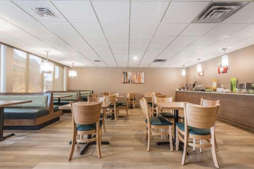 温莎Quality Inn & Suites Downtown Windsor, ON, Canada的用餐室配有木桌和椅子