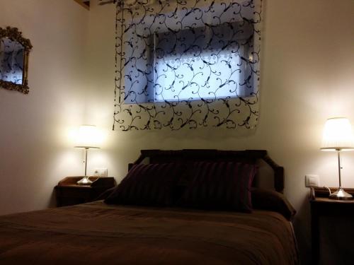La RadCasa Rural Villamoronta的一间卧室配有一张带两盏灯的床和一扇窗户。