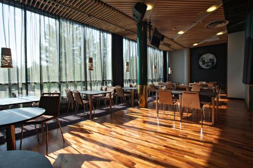 Rokua洛库阿健康Spa度假村的餐厅设有桌椅和大窗户。