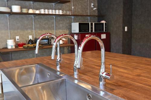 京都B&B Unagi Inn的厨房水槽和柜台上的两个水龙头