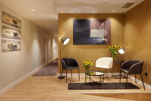 圣塞瓦斯蒂安Hotel Arrizul Beach的走廊上设有椅子、桌子和绘画