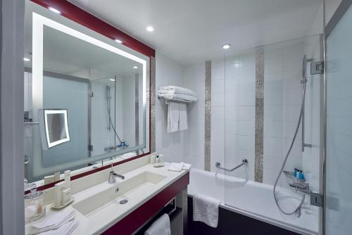 谢西Disney Hotel New York - The Art of Marvel的一间带大镜子、水槽和淋浴的浴室