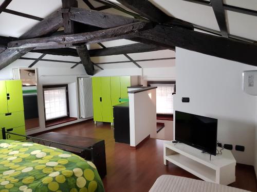 Vaprio dʼAgognaAppartamenti Old Farm的一间卧室配有一张床,并在一间客房内配有电视。