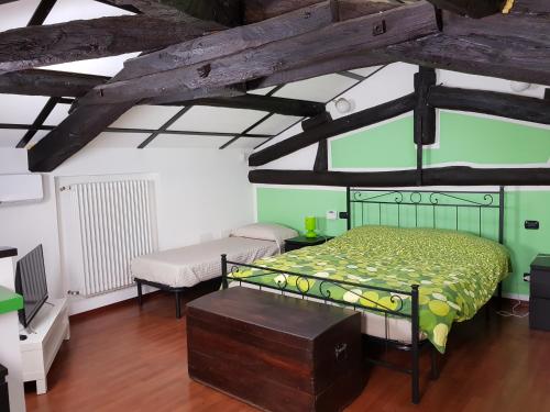 Vaprio dʼAgognaAppartamenti Old Farm的一间卧室配有绿色的床和长凳