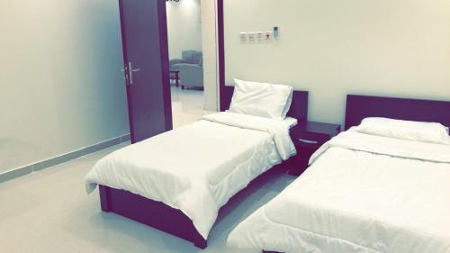 塔伊夫Al Taif Villas的一间卧室配有两张床和镜子