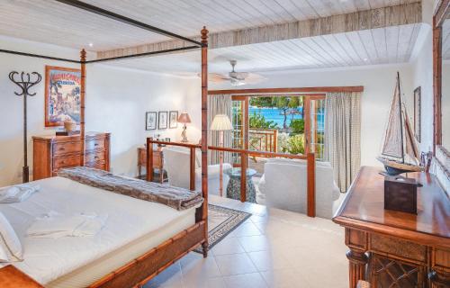 弗兰德希普Bequia Beach Hotel - Luxury Resort的一间带天蓬床的卧室和一间客厅