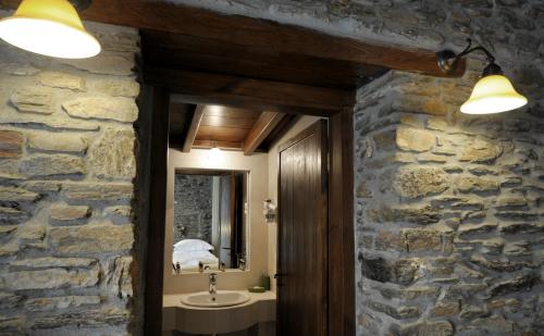 波利伊罗斯Marelia hotel的石质浴室设有水槽和镜子