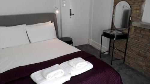 伦敦Widegate Residential的一间卧室配有一张床,上面有两条毛巾