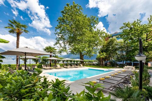 洛迦诺阿卡迪亚洛迦诺H4酒店的一个带躺椅和遮阳伞的游泳池