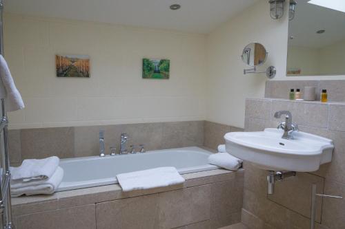 斯特劳德Vineyard Barn Room的带浴缸和盥洗盆的浴室