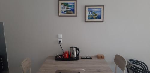 尼亚普拉莫斯Stathoris Deluxe Studio的一张桌子、一个咖啡壶和两张墙上的照片