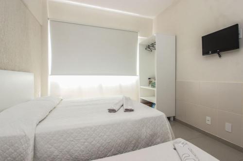 弗洛里亚诺波利斯伊尔哈诺特公寓酒店的一间卧室配有一张床和一台平面电视
