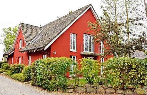米德尔哈根Ferienwohnung Moewennest mit Terra的黑色屋顶的红色房子