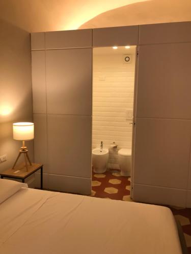 那不勒斯Palazzo Pignatelli的一间卧室配有一张床,浴室设有两个卫生间