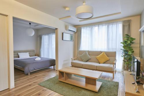 札幌PINN-N4E2Ⅱ的客厅配有床和沙发