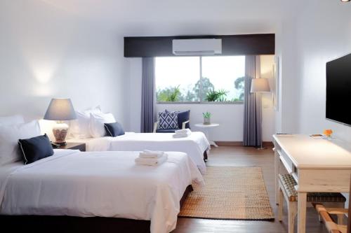 清迈La Mai Hotel的酒店客房设有两张床和一台平面电视。