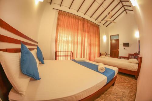 马拉维拉White Rose Beach Resort的一间卧室配有两张带蓝色枕头的床