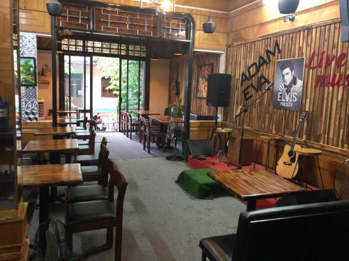 洞海亚当伊娃民宿的一间带木桌和椅子以及吉他的餐厅