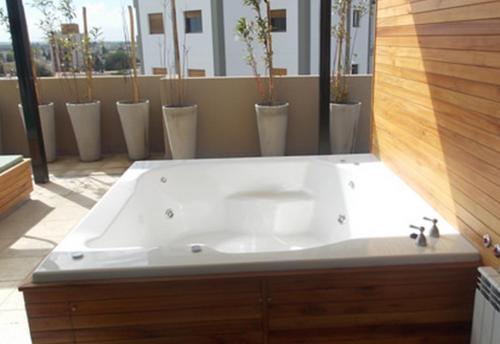 西波列蒂南多公寓式酒店的浴室内设有大型白色浴缸。